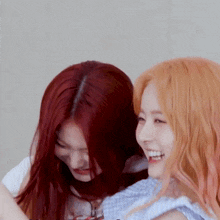 two women with red hair are smiling and laughing