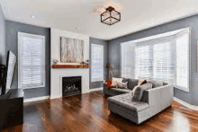 a living room with hardwood floors , a couch , a fireplace and a flat screen tv .