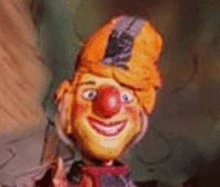 a close up of a puppet with a red nose