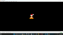 a computer screen with a santa hat on a traffic cone