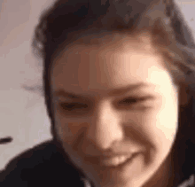 a close up of a woman 's face smiling in a video call .