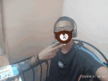 a man wearing headphones and a mask with a bear on it