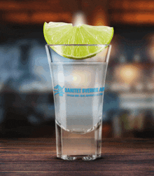 a shot glass with a slice of lime on top of it