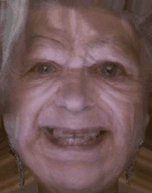 a close up of an elderly woman 's face smiling with braces on her teeth .