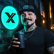 a man holding a cup of coffee in front of a sign that says x