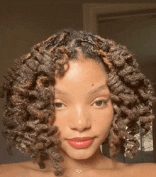 a woman with dreadlocks and a heart necklace