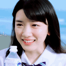 a close up of a girl holding a bottle of water with the word pibra on the bottom