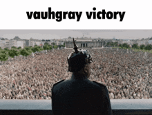 a man in a military uniform stands in front of a crowd and the words vaughray victory are above him