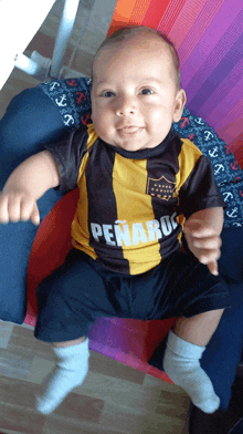 a baby wearing a jersey that says penabu on it