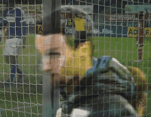 a blurred image of a soccer player behind a fence with a sign that says admiral on it