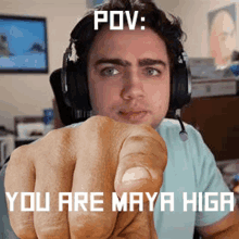 a man wearing headphones is pointing at the camera with the caption " pov : you are maya higga "