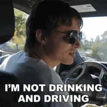 a man wearing sunglasses is driving a car with the words " i 'm not drinking and driving " below him