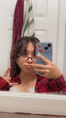 a girl wearing glasses takes a selfie with her phone