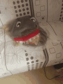 a stuffed animal in a shark costume laying on a couch