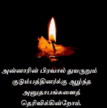 a picture of a lit candle in a dark room with a quote in tamil