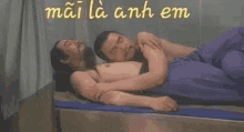 two men are laying next to each other on a bed and hugging each other .