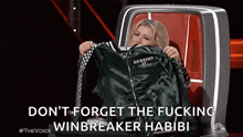 a woman in a chair holding a jacket that says season 17