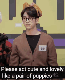 a young man wearing glasses and a headband with the words please act cute and lovely like a pair of puppies below him