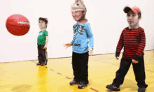 three children are playing with a basketball with their faces cut out of it