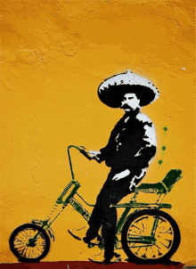 a man wearing a sombrero is riding a bicycle that says " old school " on the front