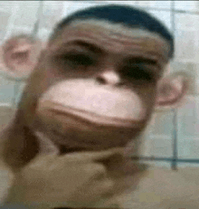 a man with a monkey face on his face is holding his hand to his chin .