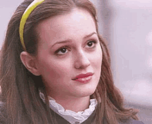 a woman wearing a yellow headband looks to the side