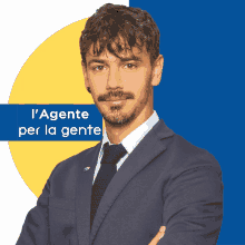 a man in a suit and tie stands with his arms crossed in front of a sign that says l' agente per la gente