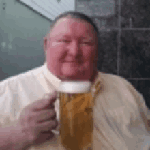 a man is holding a glass of beer and smiling .