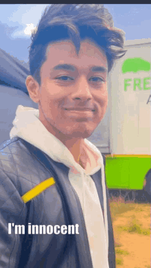 a young man standing in front of a green truck that says fresh