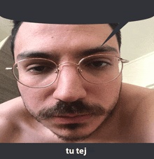 a shirtless man with glasses and a beard has a speech bubble above his head that says tu tej