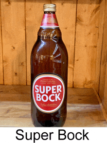 a bottle of super bock sits on a wooden table