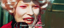 a close up of a woman 's face with pink makeup and the words `` happy hunger games ! ''