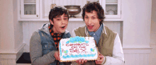 two young men are holding a cake that says congrats on the sex