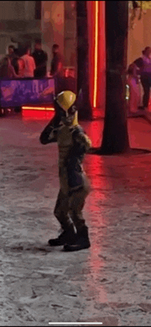 a person in a wolverine costume is standing on a sidewalk in front of a building .