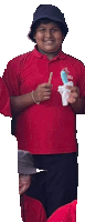 a boy in a red shirt is holding an ice cream cone and a toothbrush .