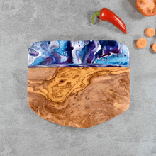 a wooden cutting board with a blue and purple painting on it