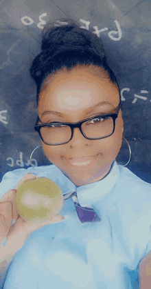 a woman wearing glasses is holding a green apple in front of a blackboard that says part 30