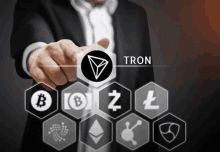 a man in a suit is pointing at a tron logo