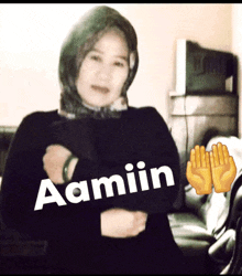 a woman wearing a black sweater with the name aamiin written on it