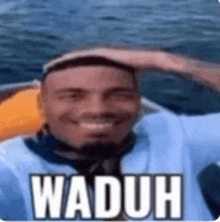 a man is sitting on a boat with his hand on his head and the word waduh written on it .