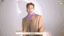 a man wearing a tan suit and a purple turtleneck is talking in korean