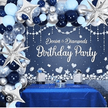 a birthday party with blue , silver , and white balloons and a table .