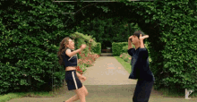 a man and a woman are dancing in a garden with a sign that says ' a ' on it