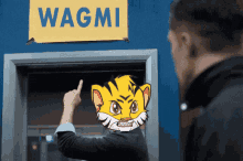 a man pointing at a sign that says wagmi on it