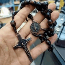 a person is holding a rosary in their hand with a crucifix .