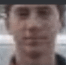 a blurry picture of a man 's face with his eyes closed .