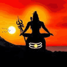 a silhouette of a deity sitting in a lotus position holding a trident at sunset .