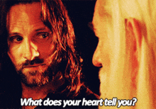 a man with long hair and a beard talks to another man with the words what does your heart tell you