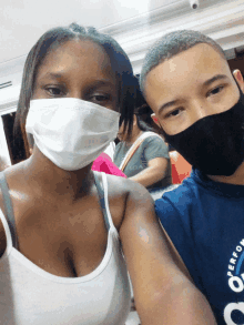 a man and woman wearing face masks pose for a picture