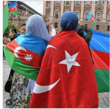 a woman in a blue hijab is holding a flag with a star on it